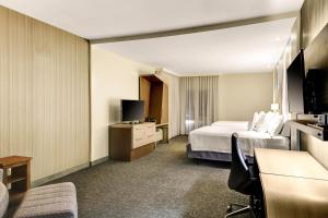 a hotel room with a bed and a television at Courtyard by Marriott New Orleans Westbank/Gretna in Gretna