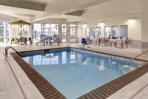 uma piscina com mesas e cadeiras num hotel em Courtyard by Marriott New Orleans Westbank/Gretna em Gretna