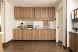 una cocina con armarios de madera en una habitación en Residence Inn by Marriott Toledo West en Toledo