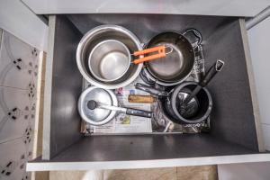 a box filled with pots and pans on a shelf at Homlee-Luxurious 2BHK Apt with Kitchen near Metro in New Delhi