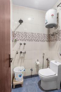 a small bathroom with a toilet and a shower at Homlee-Luxurious 2BHK Apt with Kitchen near Metro in New Delhi