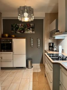 a kitchen with white cabinets and a chandelier at Villa am Park Apartment in Dresden