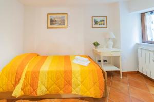 ein Schlafzimmer mit einem Bett mit einer gelben Decke und einem Tisch in der Unterkunft 094 - A Cà di Fratti, Cardini 15 minuti dal mare in Velici Inferiore