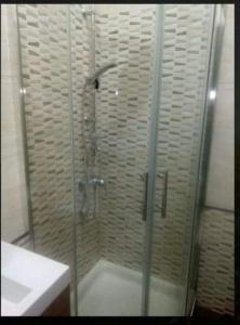 um chuveiro com uma porta de vidro ao lado de um lavatório em Villetta Maristella 1 a due passi dal mare em Capilungo