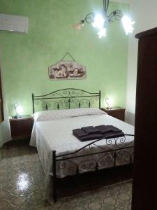 um quarto com uma cama grande com uma moldura preta em Villetta Maristella 1 a due passi dal mare em Capilungo