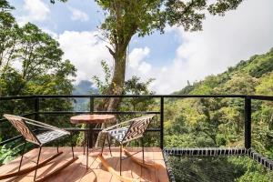 a balcony with a table and chairs and a tree at Hostal Ana in Santa Marta