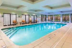 a swimming pool with blue water in a building at Courtyard by Marriott Providence Lincoln in Lincoln