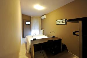 una camera con letto, scrivania e finestra di M14 Hotel & Spa a Padova