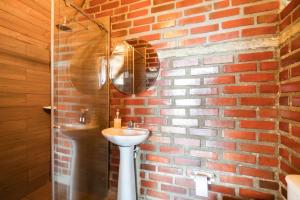 a bathroom with a brick wall and a sink at Hostal Ana in Santa Marta