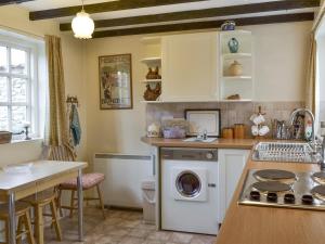 una cocina con lavadora y secadora. en Lilac Cottage en Sinnington