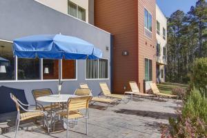 a patio with a table and chairs and an umbrella at Fairfield Inn and Suites by Marriott Natchitoches in Natchitoches