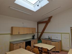 a kitchen with wooden cabinets and a skylight at Schloss Rothenklempenow in Rothenklempenow