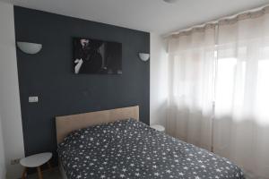 1 dormitorio con 1 cama y una foto en la pared en Mall Luxury VI Apartment, en Bacău