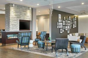 a waiting room with chairs and a table and a fireplace at Residence Inn by Marriott Albany Airport in Albany