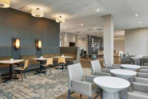 a waiting room with tables and chairs in a hospital at Residence Inn by Marriott Albany Airport in Albany
