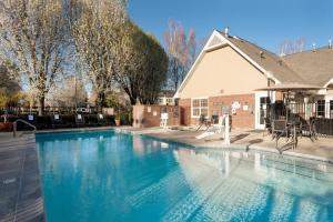 a large swimming pool in front of a house at Residence Inn by Marriott Stockton in Stockton