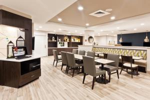 a restaurant with a bar and tables and chairs at TownePlace Suites by Marriott Montgomery EastChase in Montgomery