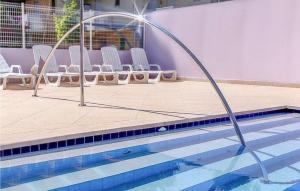 einen Pool mit einem Wasserschlauch, der herausragt in der Unterkunft Beautiful Apartment In Bibione With Outdoor Swimming Pool in Bibione