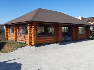 uma cabana de madeira com telhado e janelas em Casa Tisa em Oradea