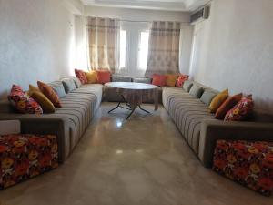 appartement en plein centre de casablanca في الدار البيضاء: غرفة معيشة مع أريكة كبيرة وطاولة