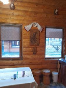 - une chambre avec 2 fenêtres dans un mur en bois dans l'établissement CABANA TISA, à Băile Felix