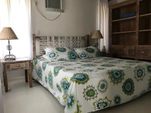 um quarto com uma cama com um edredão floral em Villa Oberoi pé na areia alto luxo em Santo André