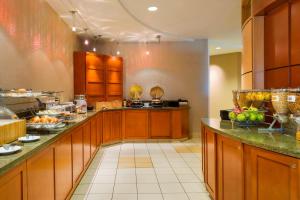 a large kitchen with wooden cabinets and fruits on the counters at SpringHill Suites by Marriott Omaha East, Council Bluffs, IA in Council Bluffs