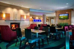 a restaurant with tables and chairs and a fireplace at SpringHill Suites by Marriott Omaha East, Council Bluffs, IA in Council Bluffs