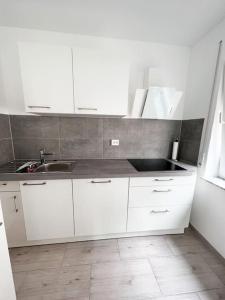 a kitchen with white cabinets and a sink at Neu sanierte Einzimmerwohnung in Bad Nauheim