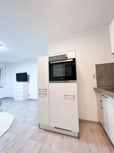 a kitchen with a white refrigerator and a microwave at Neu sanierte Einzimmerwohnung in Bad Nauheim