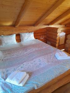 - une chambre avec un lit dans une cabane en bois dans l'établissement CABANA TISA, à Băile Felix