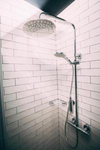 um chuveiro de azulejos brancos com uma cabeça de chuveiro em Thomas Moore Inn em Dublin