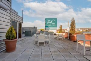 um pátio com mesas e cadeiras num edifício em AC Hotel Guadalajara by Marriott, Spain em Guadalajara