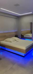 Bett in einem Zimmer mit blauen Lichtern in der Unterkunft Motel Monza (Adult Only) in Santos