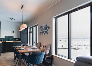 a dining room with a table and chairs and a large window at Skidbakki Guesthouse in Kross