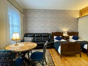 una camera d'albergo con divano e tavolo di Lielbornes Muiža Boutique Hotel&Recreation Complex a Lielborna