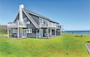 una grande casa su un prato con l'oceano sullo sfondo di Pet Friendly Apartment In Nykbing Sj With Wifi a Højby