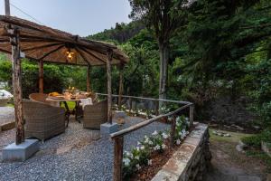 un jardin avec une table et un kiosque dans l'établissement Rio delle Fate, a Fairytale Home along the Stream in Vorno, Lucca, à Capannori