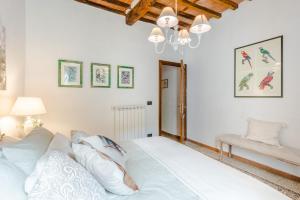 - une chambre blanche avec un lit et un lustre dans l'établissement Rio delle Fate, a Fairytale Home along the Stream in Vorno, Lucca, à Capannori