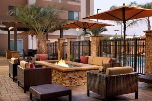 un patio con una hoguera, sillas y sombrillas en Courtyard by Marriott San Diego Oceanside, en Oceanside