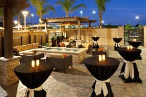 a patio with tables and chairs and a pool at Courtyard by Marriott San Diego Oceanside in Oceanside