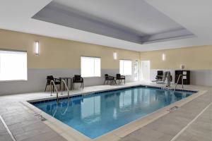uma piscina num quarto com cadeiras e uma mesa em TownePlace Suites by Marriott Sumter em Sumter