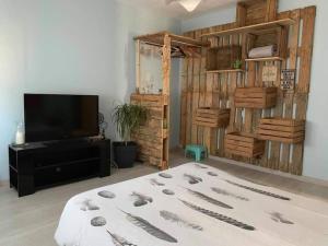 a living room with a bed and a flat screen tv at gite des huskys in Tonnay-Charente