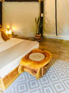 a bedroom with a bed with a wooden table on the floor at Tribu EcoHostal in Los Santos