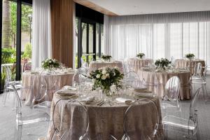 a banquet hall with tables and chairs with flowers at AC Hotel by Marriott Fort Lauderdale Sawgrass Mills Sunrise in Sunrise