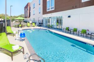 a swimming pool at a hotel with chairs and a building at SpringHill Suites Houston Pearland in Pearland