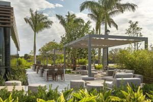 a patio with tables and chairs and a pavilion at AC Hotel by Marriott Fort Lauderdale Sawgrass Mills Sunrise in Sunrise