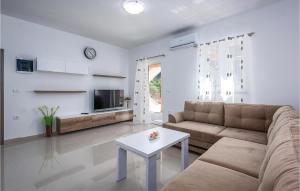 ein Wohnzimmer mit einem Sofa und einem Tisch in der Unterkunft Amazing Home In Plomin With 3 Bedrooms, Wifi And Outdoor Swimming Pool in Plomin