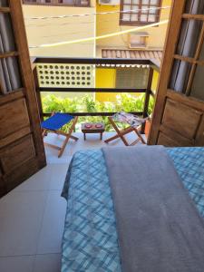um quarto com uma varanda com uma mesa e uma cadeira em Suíte na vila de Praia do Forte na Praia do Forte