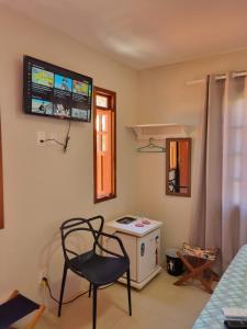 um quarto com uma cadeira, um fogão e uma janela em Suíte na vila de Praia do Forte na Praia do Forte